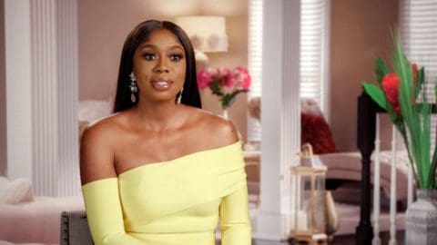 Wendy Osefo wears off the shoulder yellow dress while filming RHOP confessional inside her Finksburg, MD home.